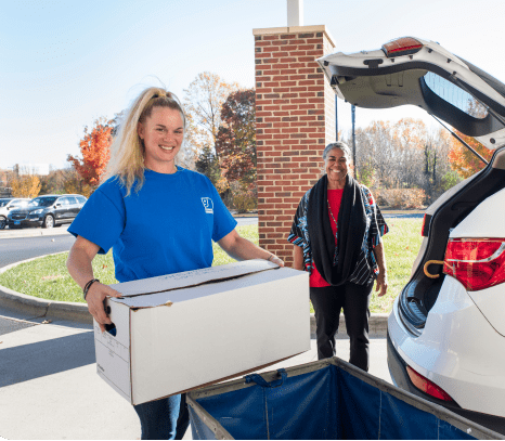 Goodwill worker unloading the trunk of a woman's vehicle