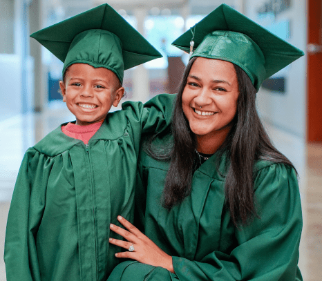 Goodwill graduate and her son with cap and gown on