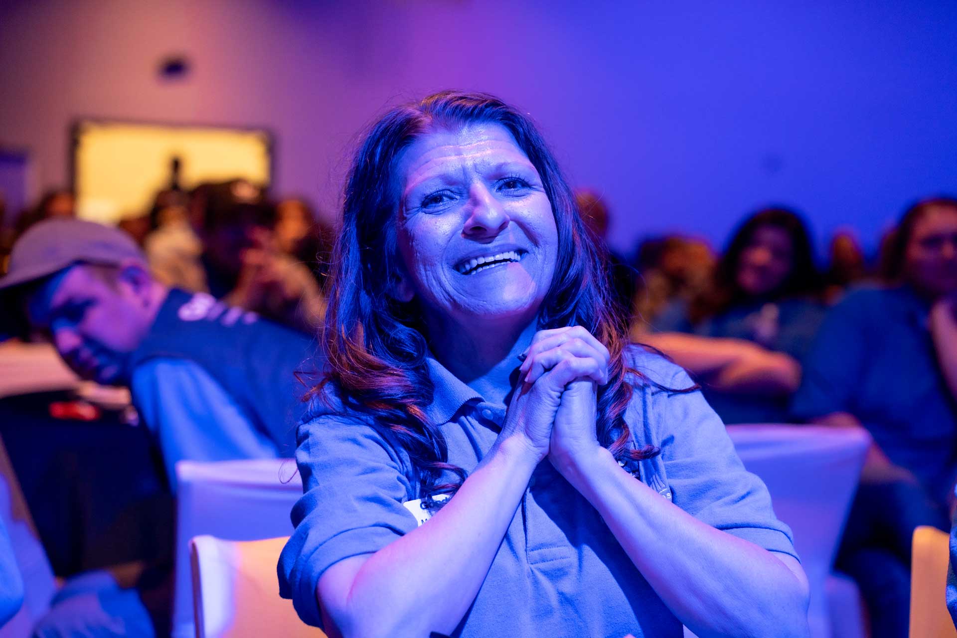 Woman grasping her hands in delight at goodwill event