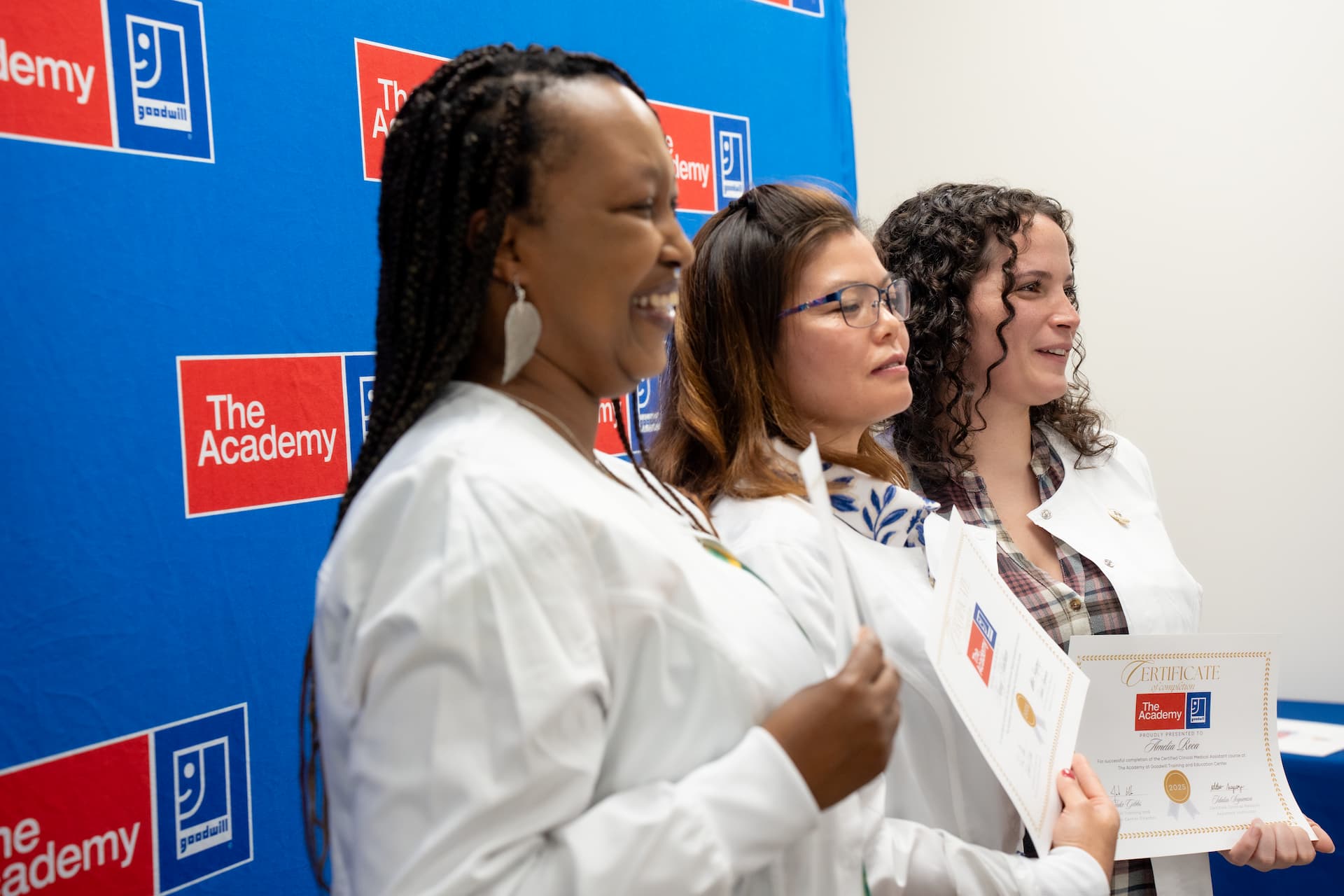 Women holding up certificates of completion